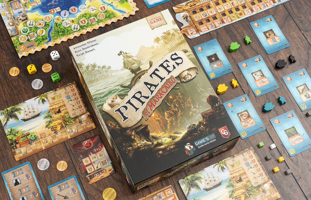 Pirates of Maracaibo box surrounded by spread-out game components including boards, cards, dice, coins, and wooden meeples on a wooden table.