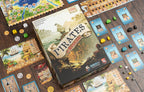 Pirates of Maracaibo box surrounded by spread-out game components including boards, cards, dice, coins, and wooden meeples on a wooden table.