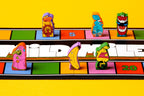 Five colorful wooden character meeples from Magical Athlete placed on a vibrant multicolored race track game board with numbered spaces.