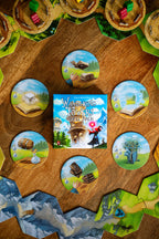 Wandering Towers Spell Pack box surrounded by circular spell tiles and hexagonal terrain tiles with wooden tower pieces on a wooden surface.