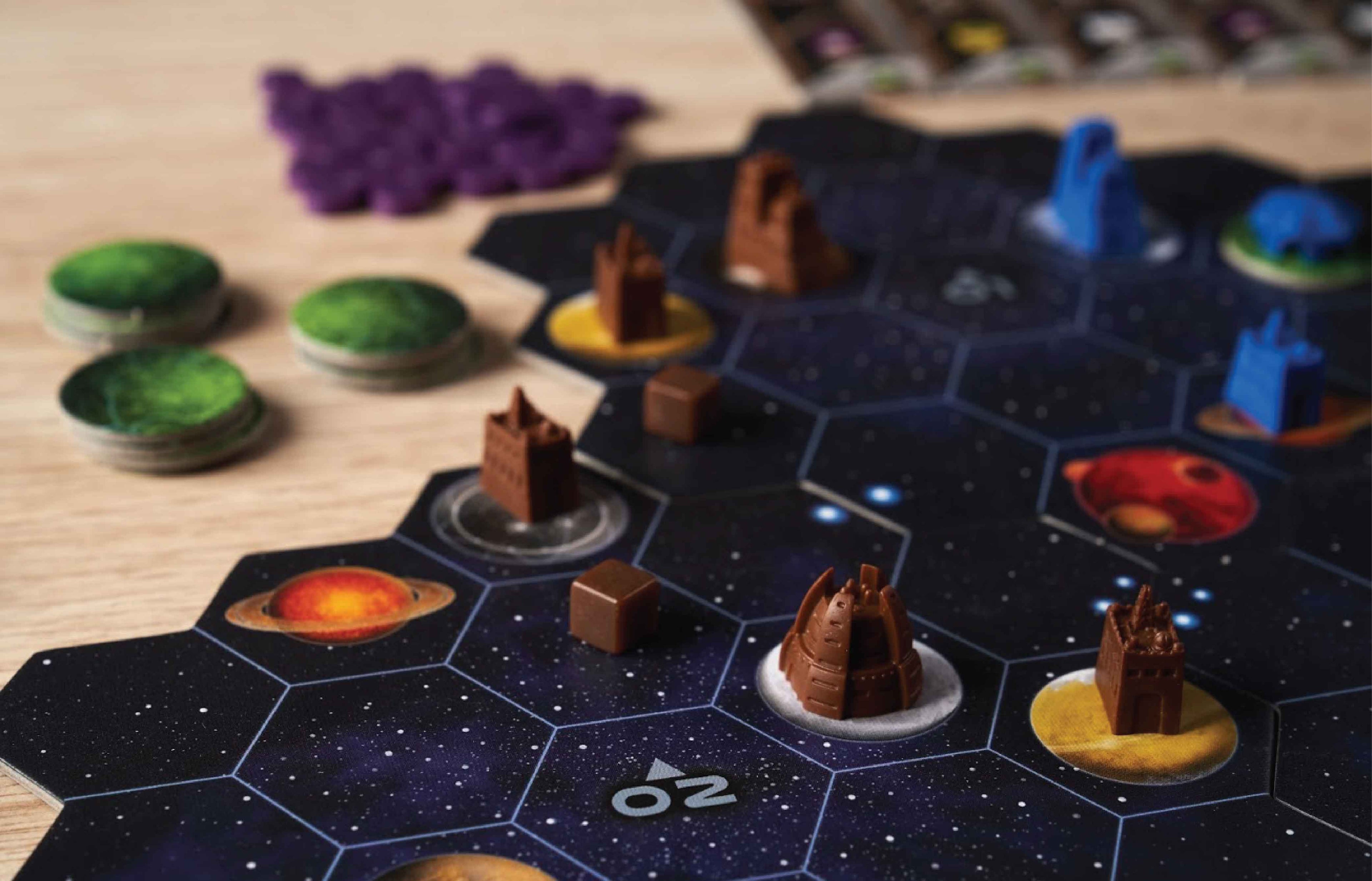 Close-up of Gaia Project's hex-tile space board showing brown and blue faction buildings on planet tokens with green and purple pieces nearby.