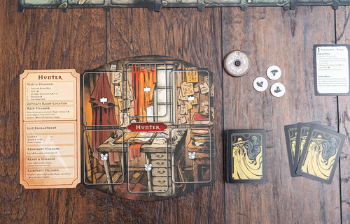 Pagan: Fate of Roanoke Hunter player board displayed on wood surface alongside action cards, token coins, and a player aid card.