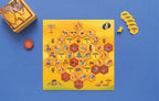 Savannah Park board game laid out showing the hexagonal tile game board with safari animals, plus the game box, wooden meeple, and acacia tree hexagon tiles.