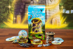 Wandering Towers: The Magic Tower expansion box surrounded by game components including tower miniatures, round tiles, meeples, and token pieces on a wooden table.