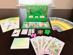 Wingspan Americas Expansion components spread on a table including player mats, bird cards, action cubes, green eggs, and rulebook.