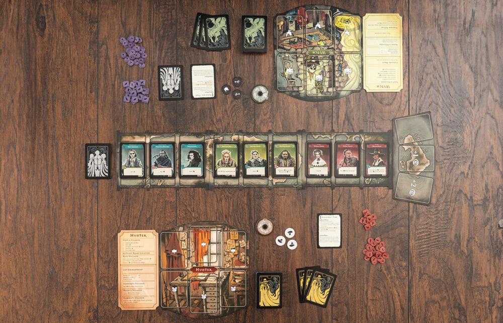 Pagan: Fate of Roanoke components flat-lay showing character cards, player boards, tokens, and cards spread on a wooden surface.