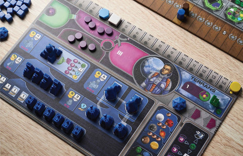 Gaia Project Terrans faction board in play, covered with blue spaceships, mines, and purple resource tokens on a wooden table.