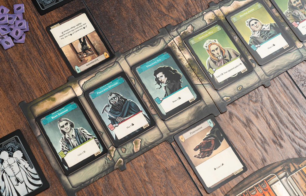 Pagan: Fate of Roanoke character and action cards spread across a wooden table, showing illustrated colonist figures and game mechanics text.