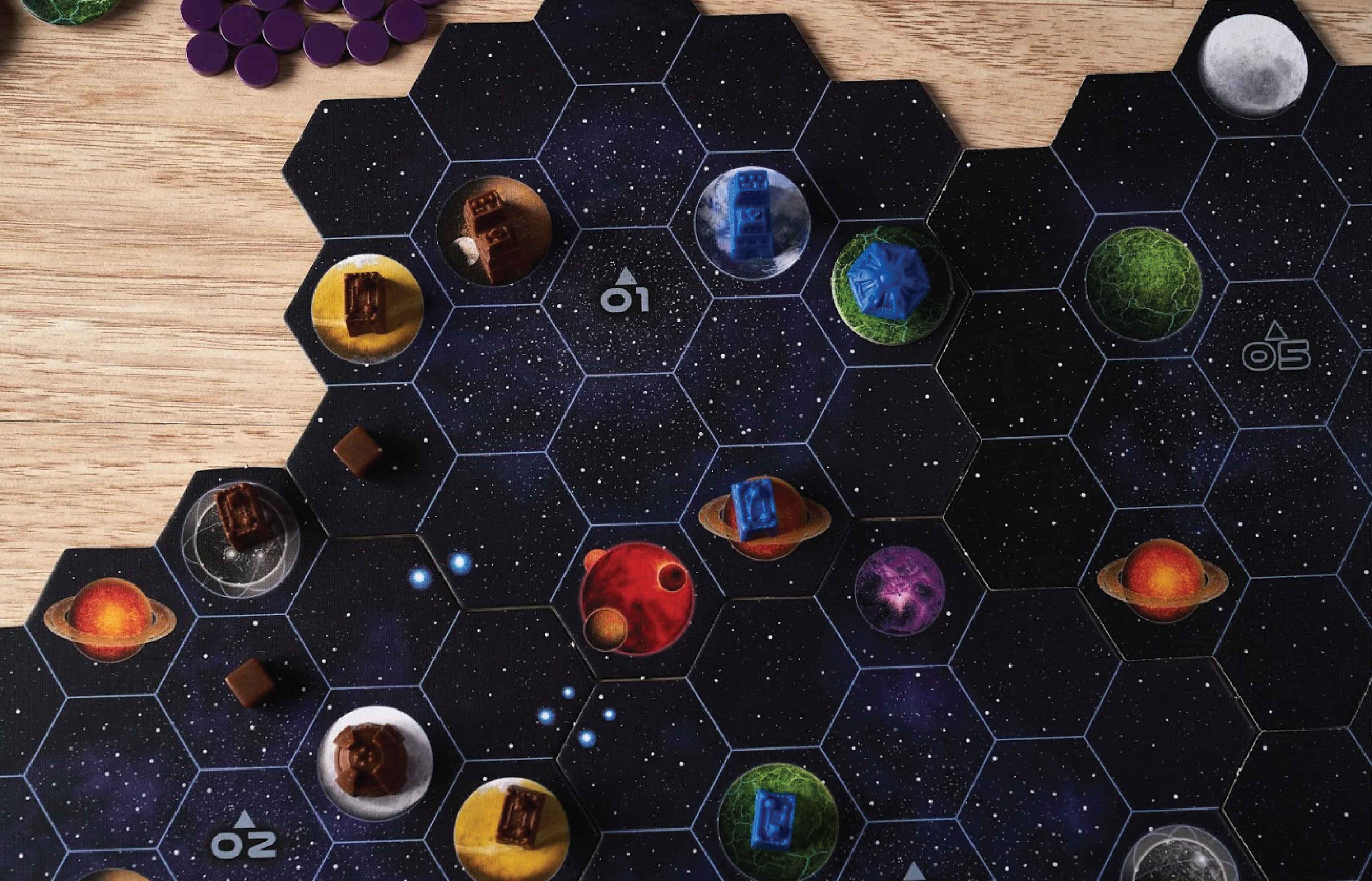 Close-up of Gaia Project's hex-tile space board showing colorful planet tiles with brown and blue player structures placed on them.